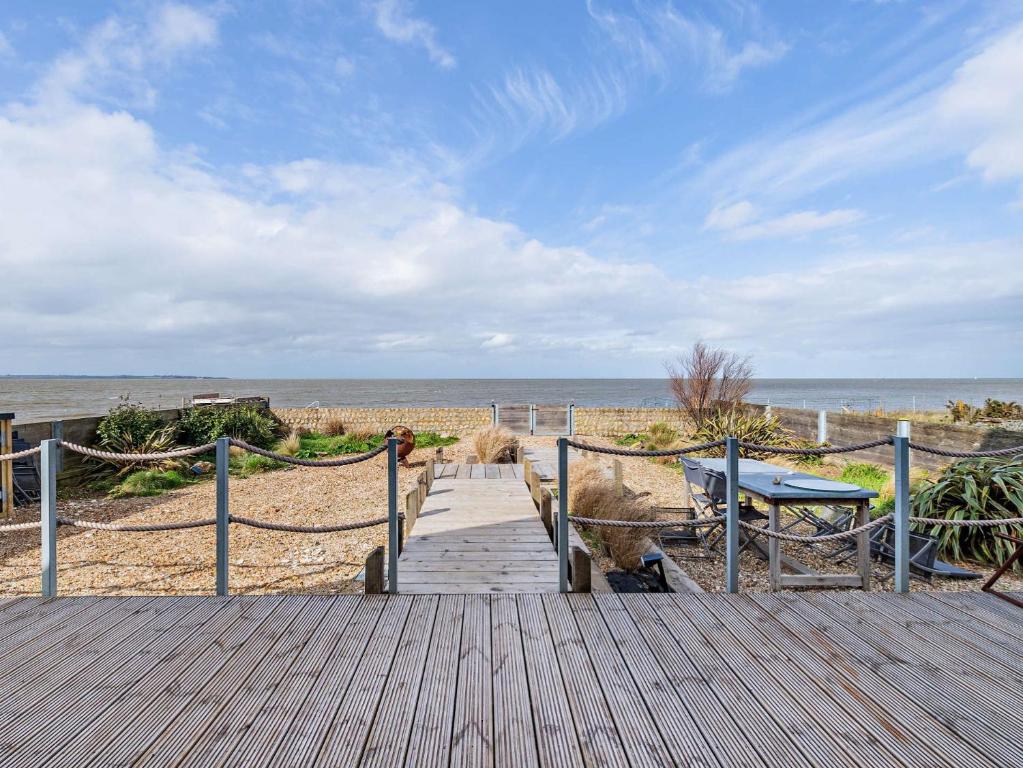 um calçadão de madeira que leva à praia com uma mesa de piquenique em 3 Bed in Whitstable 91641 em Seasalter