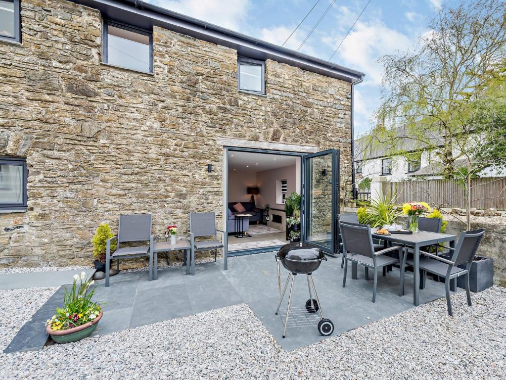 a patio with a table and chairs in front of a brick building at 2 Bed in Barnstaple 91637 in Fremington