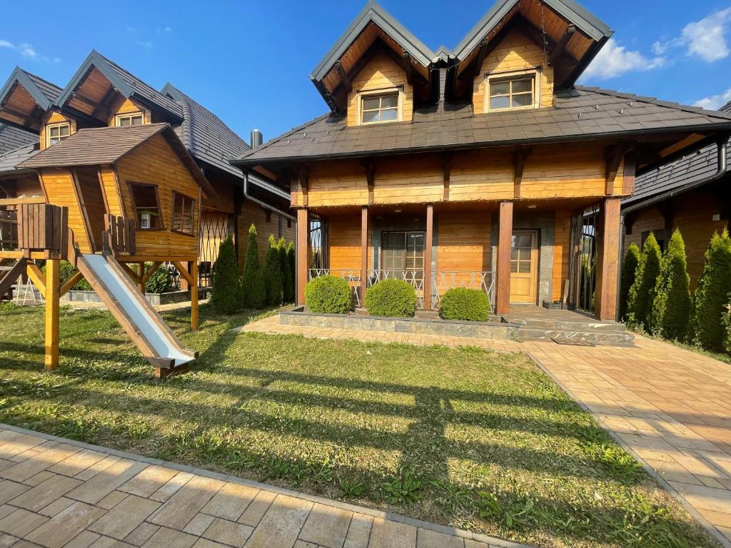 a house with a slide in front of it at Mountain Villa Zlatibor in Zlatibor