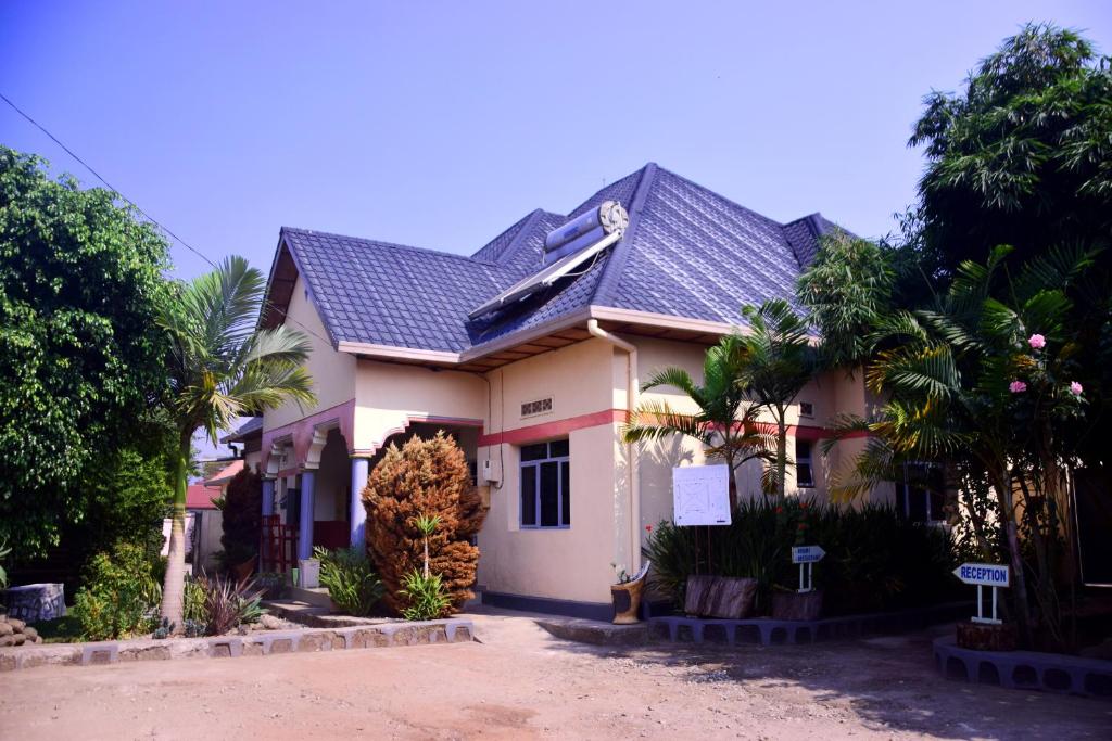 una casa blanca con techo negro en La Natura Guest House en Ruhengeri