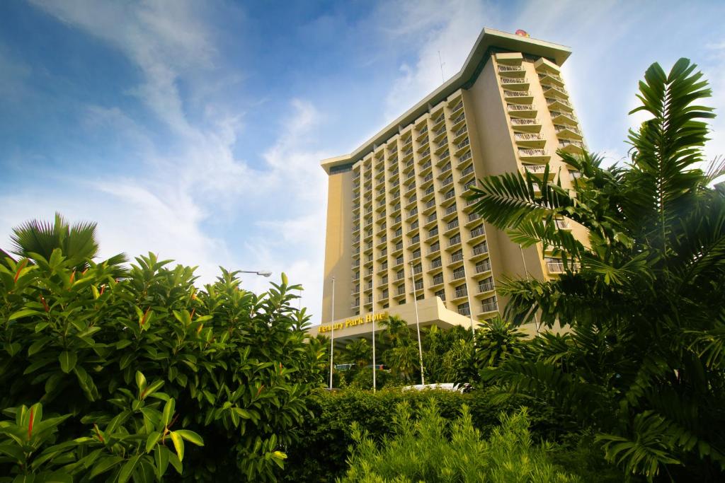 Century Park Hotel في مانيلا: مبنى طويل وبه أشجار أمامه