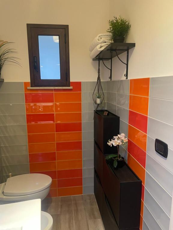 La salle de bains est pourvue de toilettes et de carrelage coloré. dans l'établissement Archetto-casa vacanze, à Enna