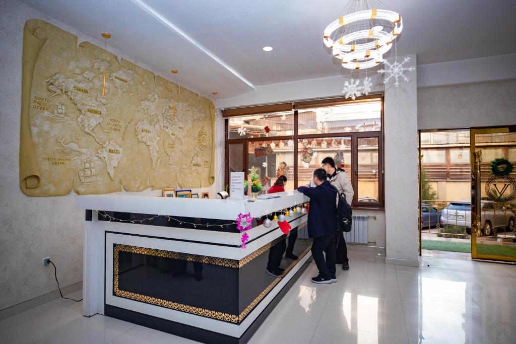 grupa ludzi stojących przy ladzie w restauracji w obiekcie VATAN DUSHANBE HOTEL w mieście Duszanbe