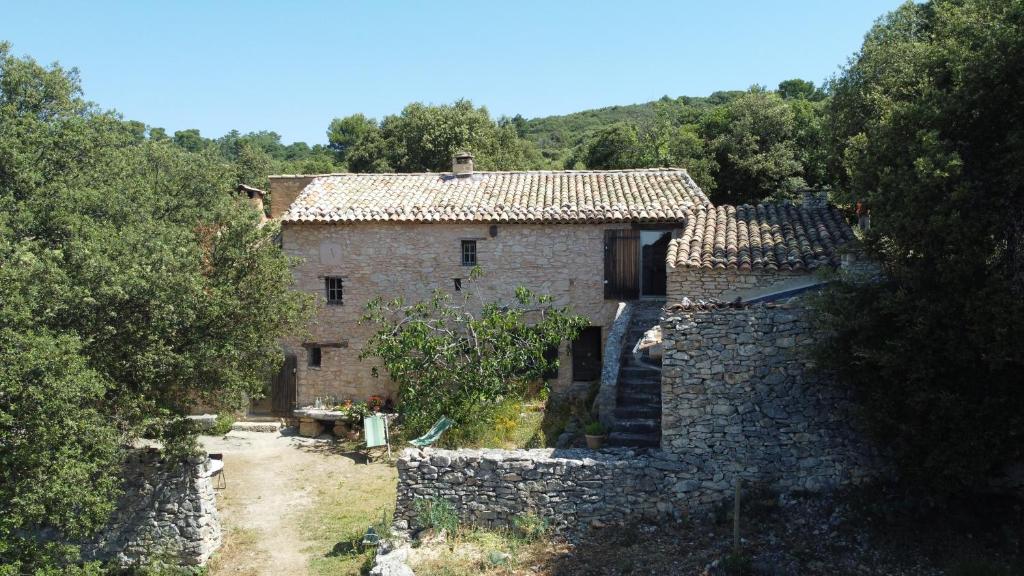 an old stone house in the middle of a forest at Le Jas des aiguiers in Saint-Saturnin-dʼApt