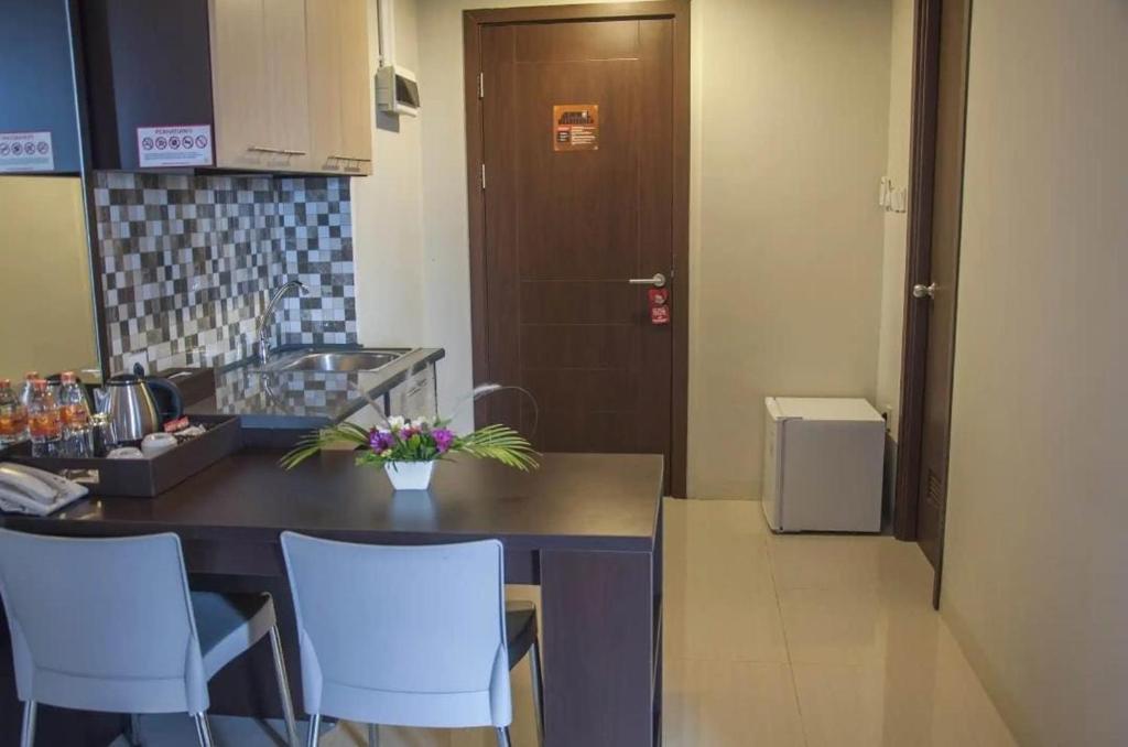 una cucina con tavolo, sedie e porta di Mugiwara Hotel&Apartment a Batulicin