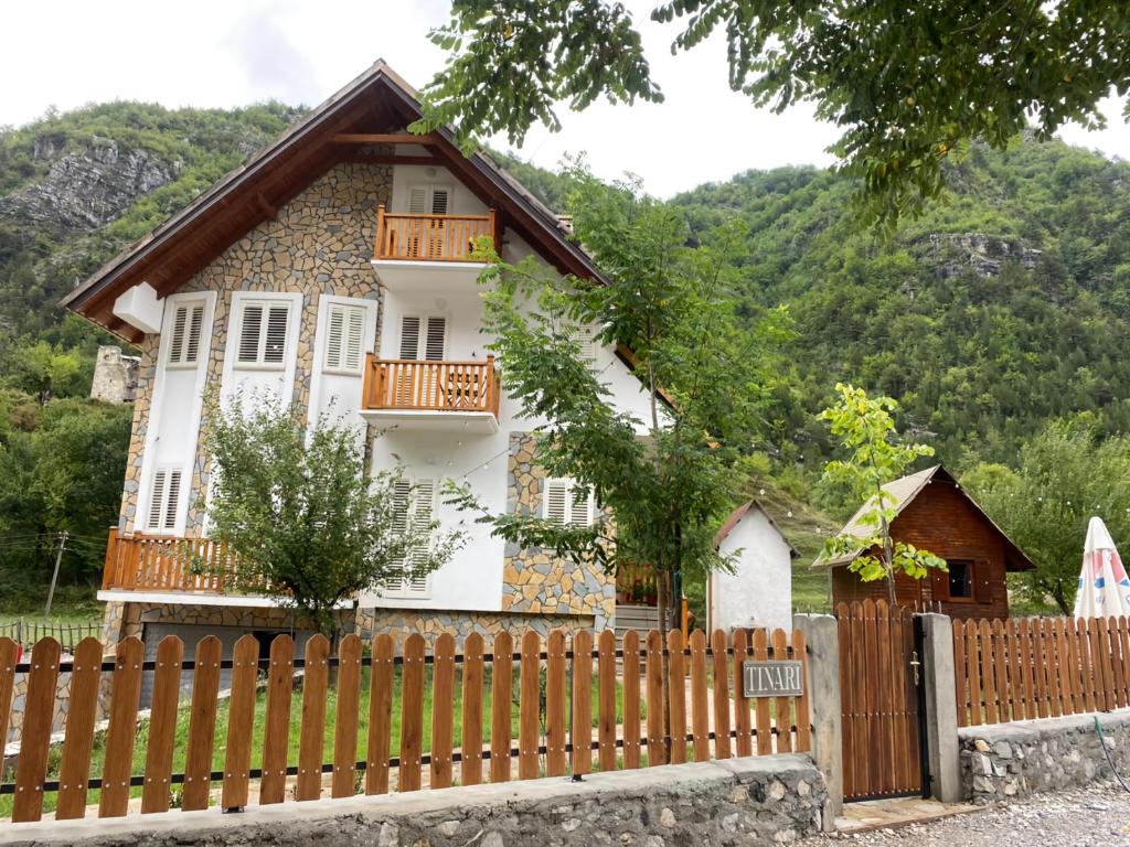 une maison avec une clôture en bois devant elle dans l'établissement Bujtina Tinari Theth, à Theth