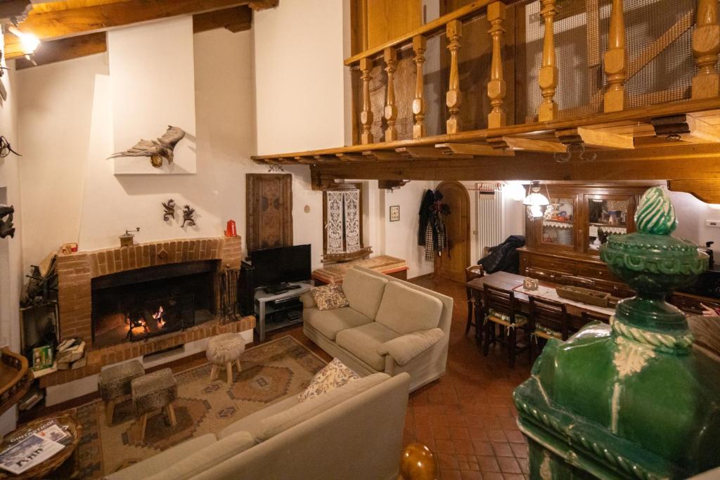 uma sala de estar com um sofá e uma lareira em Chalet Corona em Giustino