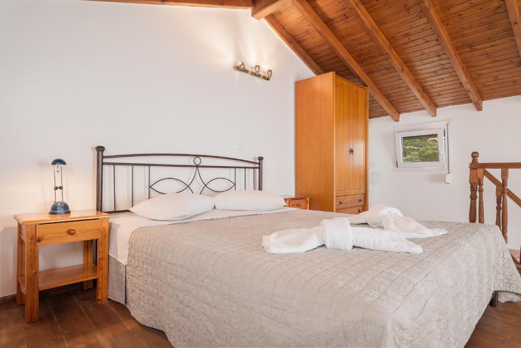 sypialnia z łóżkiem i dwoma ręcznikami na nim w obiekcie Ether Farmhouse w mieście Samos
