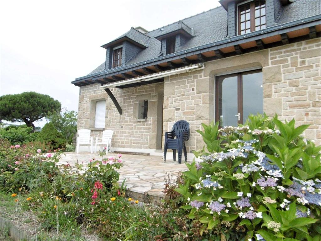 ein Steinhaus mit einer Terrasse und Blumen in der Unterkunft Maison 4 pièces 6 personnes, vue sur l'océan - Carantec in Sarzeau