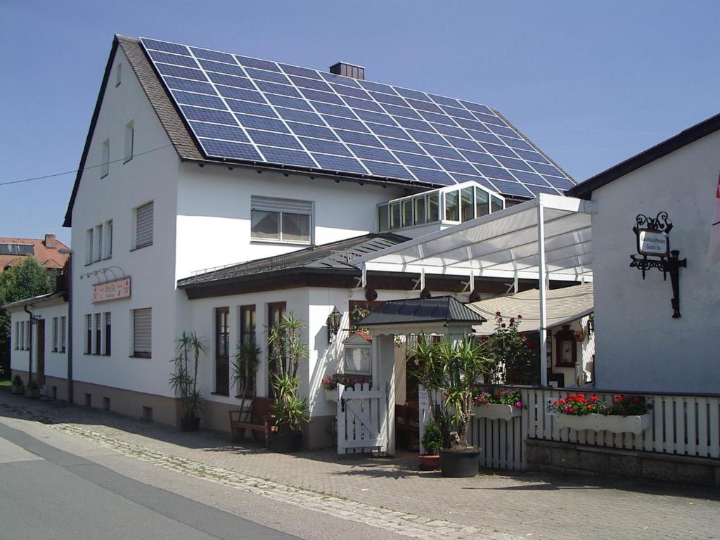 ein Haus mit Sonnenkollektoren auf dem Dach in der Unterkunft Gasthof Pension Grüne Au 