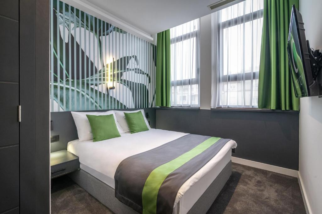 貝爾格勒的住宿－City Joy - sports Center Tasmajdan，一间卧室配有一张带绿色窗帘的床