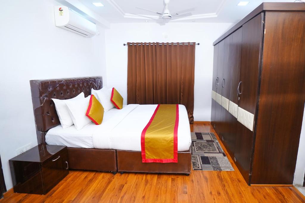- une chambre avec un lit et une grande armoire en bois dans l'établissement Hotel Brundavan Homes, à Hyderabad