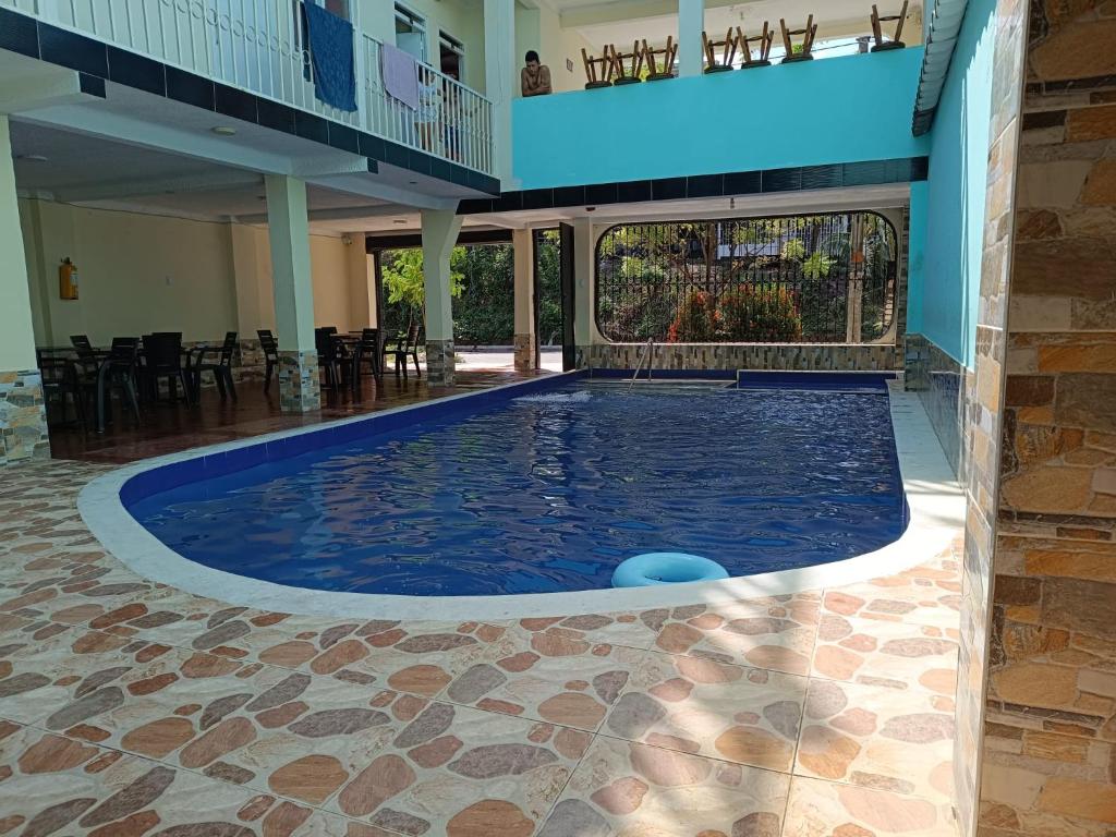 a large swimming pool in a building with a patio at Cambulos House in Melgar