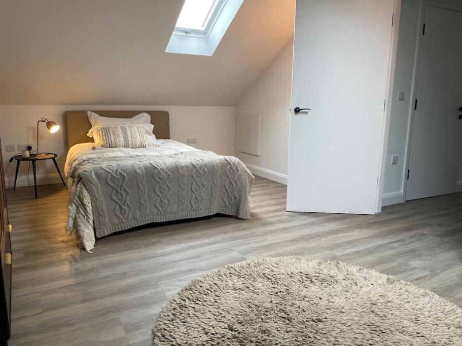 um quarto com uma cama, um tapete e uma janela em Apartment over barn with views em Mobberley