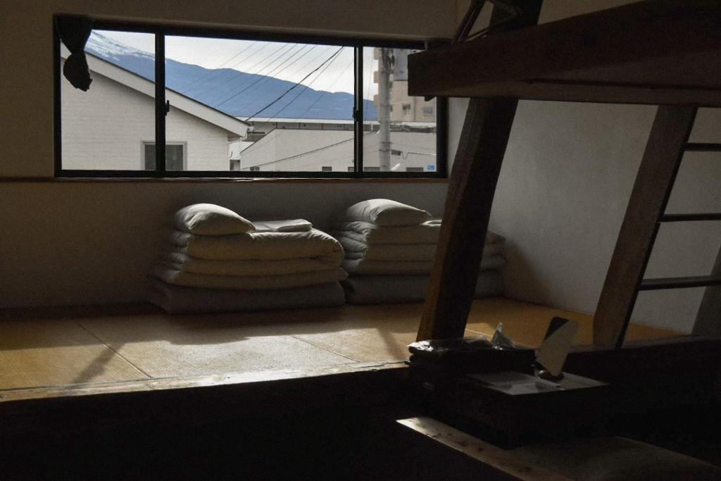 a living room with a large window and couches at kagelow Mt.Fuji Hostel Kawaguchiko in Fujikawaguchiko