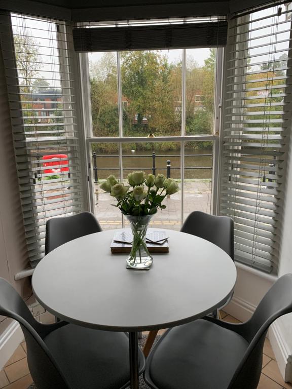 a white table with chairs and a vase of flowers at Belle View cottage in Bewdley