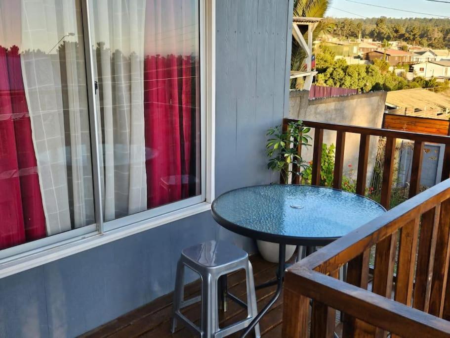 d'un balcon avec une table bleue et une fenêtre. dans l'établissement Cabaña de 2 habitaciones, à El Tabo
