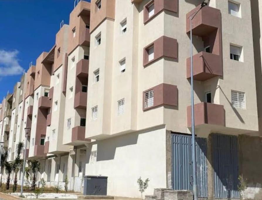 - un bâtiment avec des balcons sur le côté dans l'établissement Holikeys - Fès - 2 Ch - Lot Ofok 004, à Fès