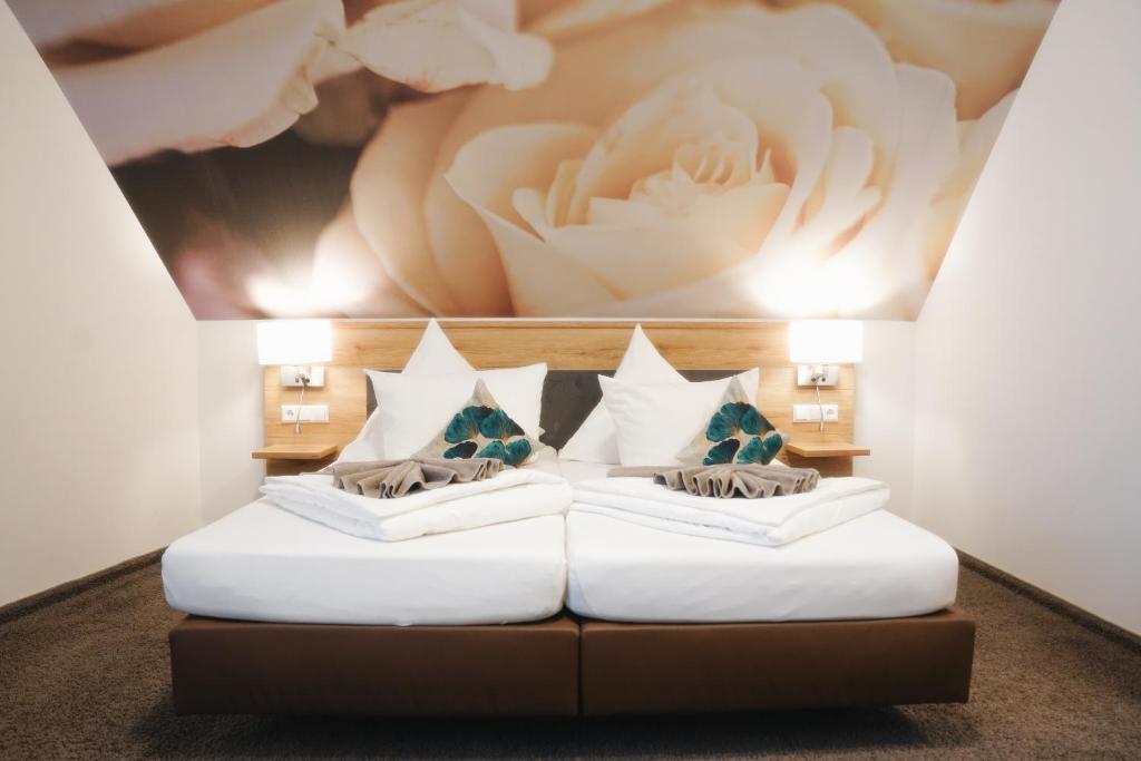 2 Betten in einem Zimmer mit Wandgemälde in der Unterkunft Outlet Hotel in Metzingen