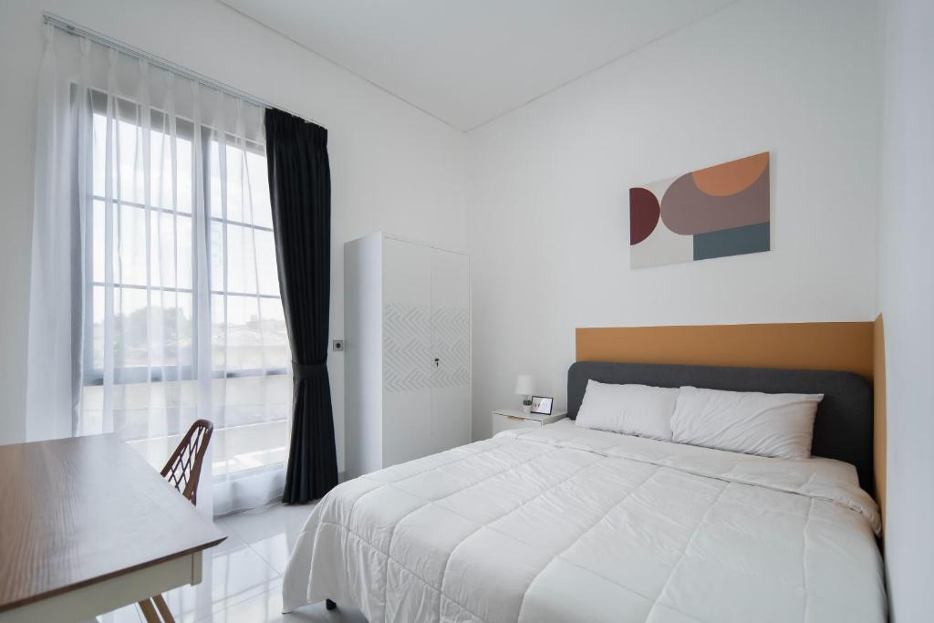 a bedroom with a bed and a table and a window at Cove River Haus in Jakarta
