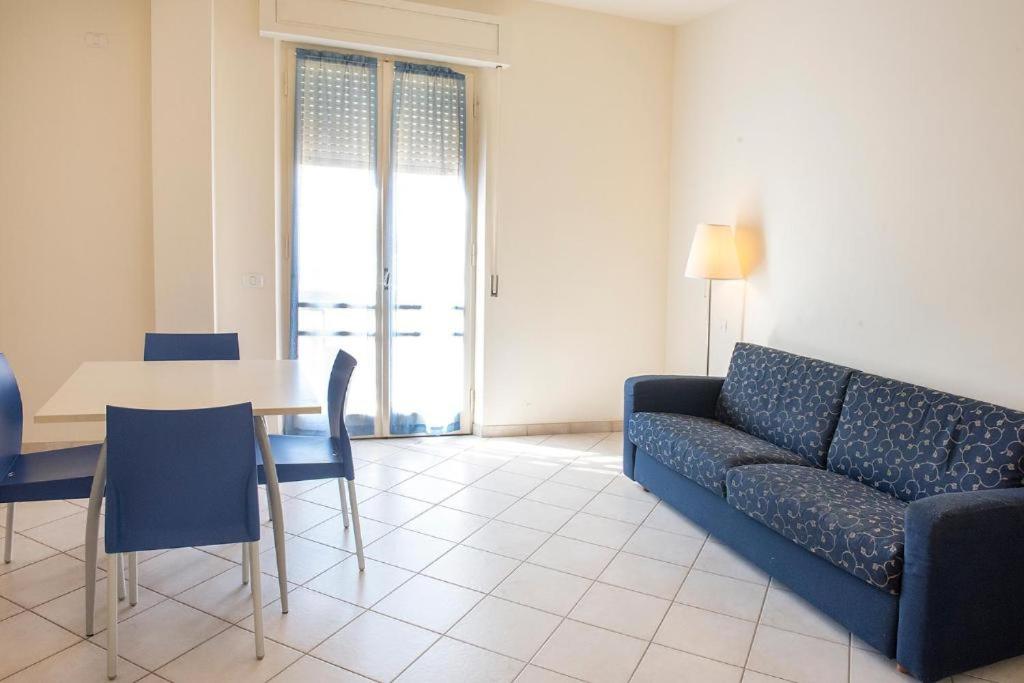 sala de estar con sofá azul y mesa en Bilocale fronte mare a Marcelli – M030, en Marcelli
