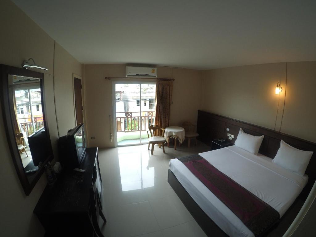 ein Hotelzimmer mit einem Bett und einem TV in der Unterkunft Chiangkhong Green Inn Resident in Chiang Khong