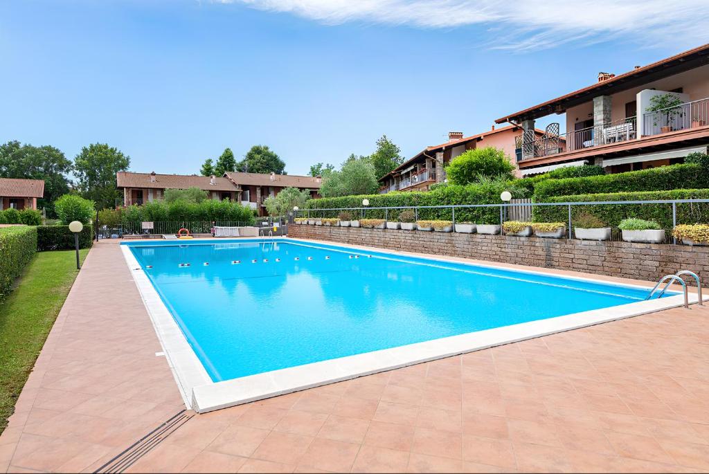 a large blue swimming pool in a yard at I BROLI - lovely nest with pool in Polpenazze del Garda