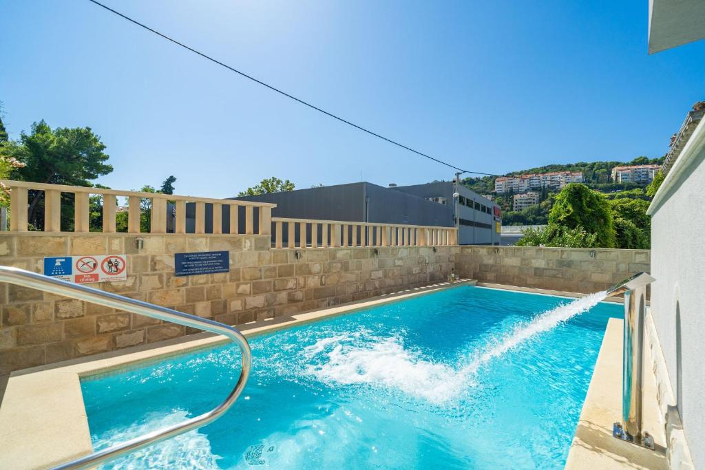 a swimming pool with a water fountain at Apartments Villa Aura in Dubrovnik