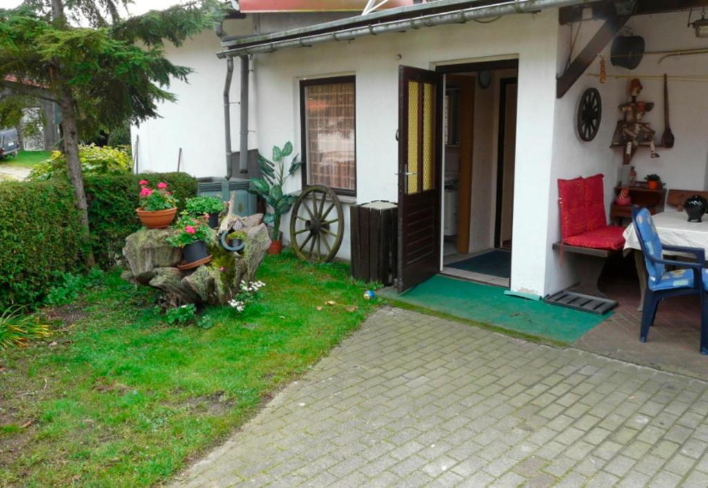 uma pequena casa com um sofá vermelho e um alpendre em Ferienwohnung in Plau am See em Plau am See