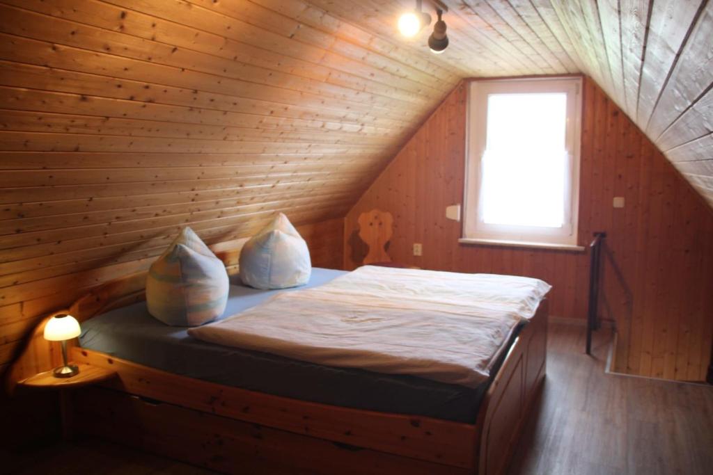 1 dormitorio con 1 cama en una habitación de madera en Ferienhaus Mecklenburgische Seenplatte, 