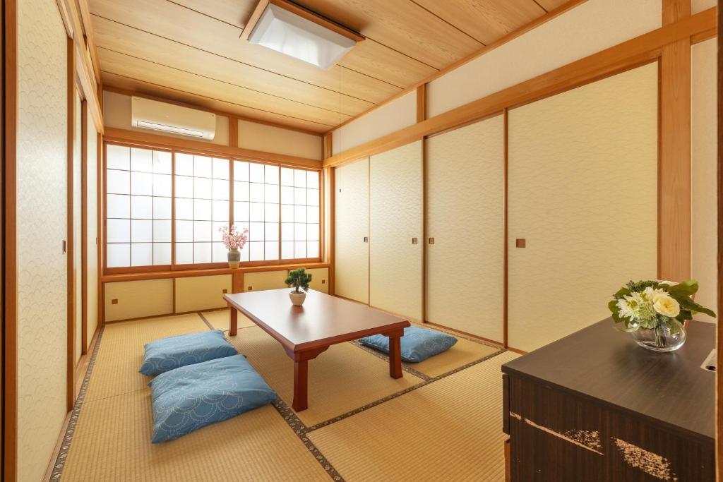 Habitación japonesa con mesa y cojines azules en Fukuei Stay Tokyo, en Tokio