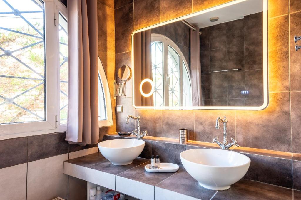 a bathroom with two sinks and a mirror at Porto Rafti Hideaway in Porto Rafti
