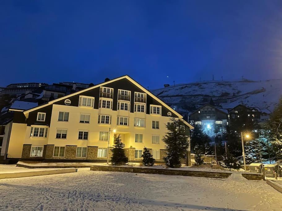 a large building with snow in front of it at Maribel Confort in Sierra Nevada