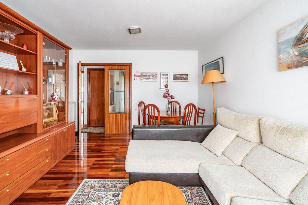 een woonkamer met een bank en een tafel bij Piso con Piscina in Santander