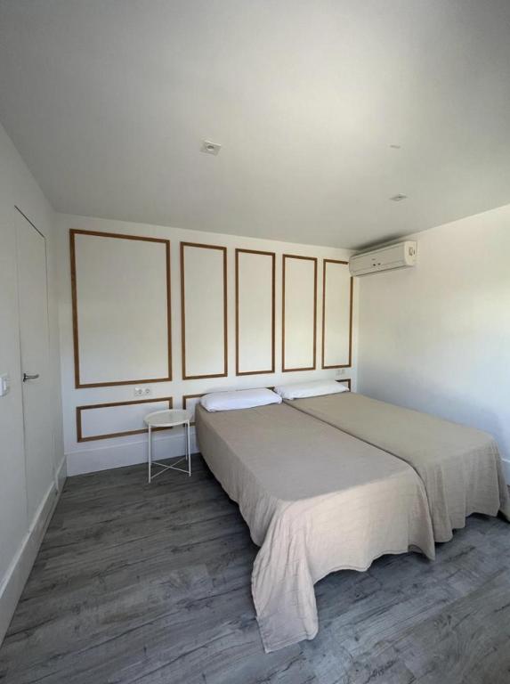 Un dormitorio blanco con una cama grande y una ventana en BUNGALOWS BEDANDBEACH, en El Palmar