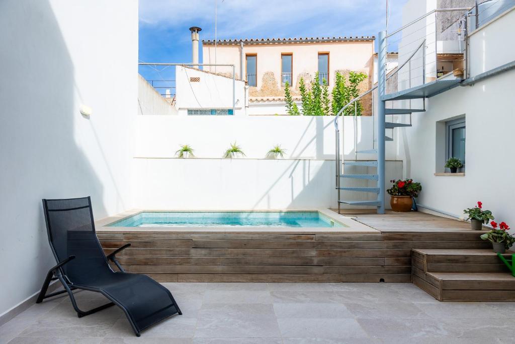 een huis met een dompelbad en een stoel bij Sa Botigueta Petit in Artá