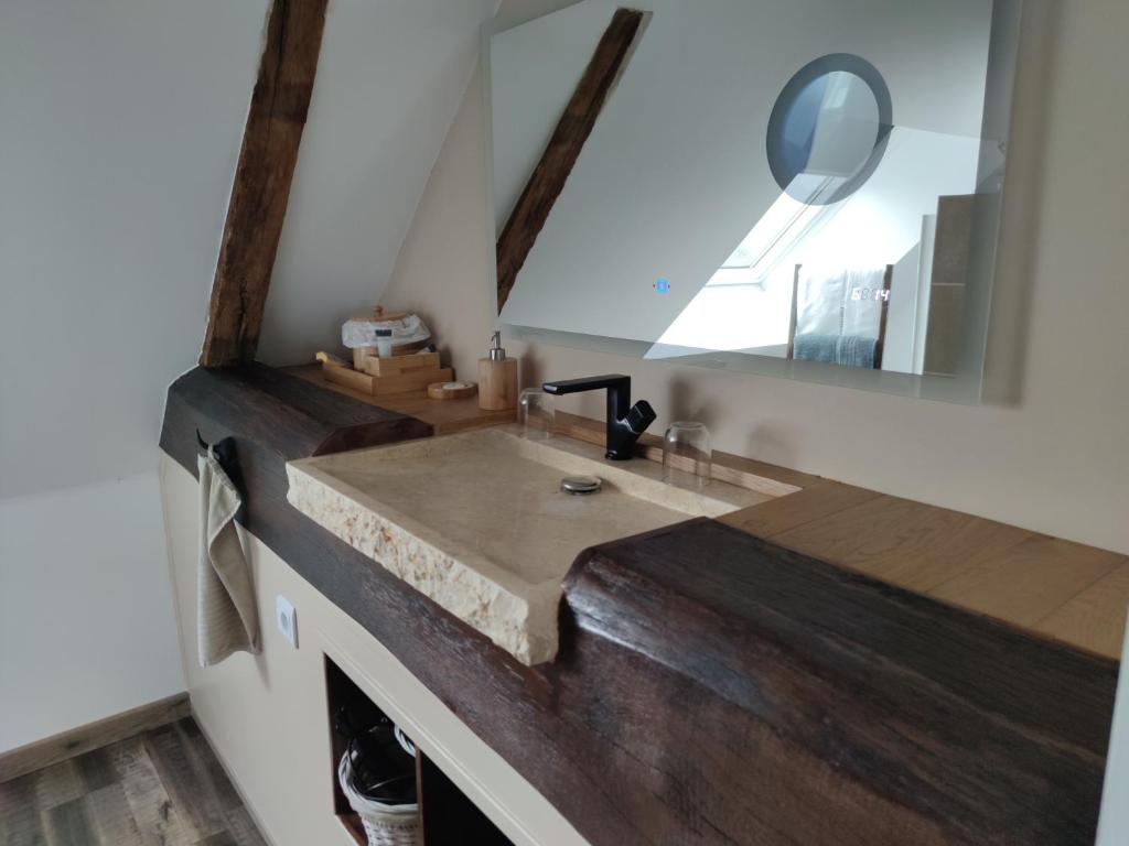 uma casa de banho com um lavatório de madeira e um espelho em Chambre d hôte Beaumont pied de bœuf em Beaumont-Pied-de-Boeuf