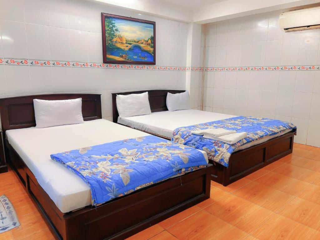 two beds sitting next to each other in a room at Khách Sạn Nam Đô 1 in Can Tho
