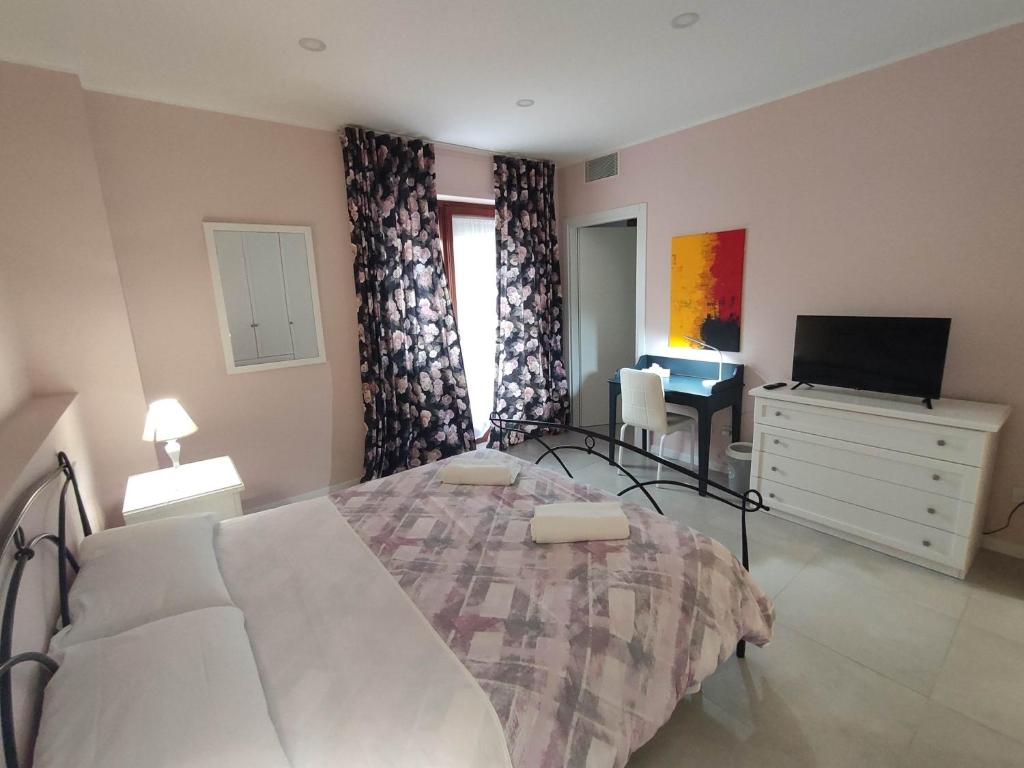 a bedroom with a bed and a dresser and a television at GArt Riviera B&B in Pescara