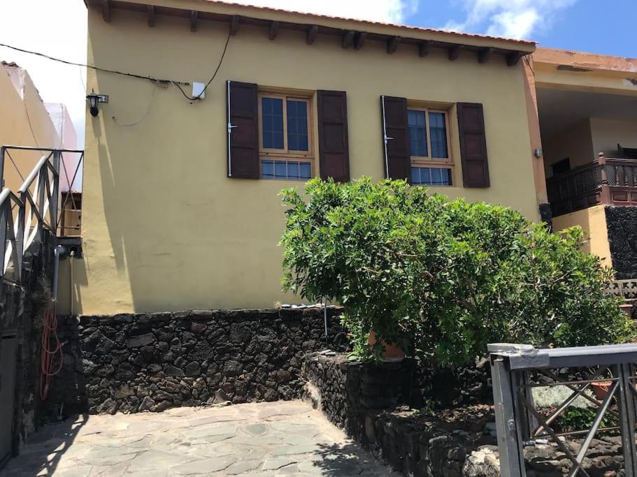 a house with a stone wall in front of it at Una casa con vistas in La Caleta