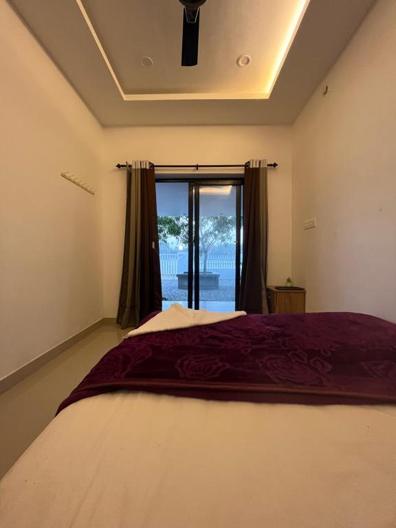 a bedroom with a large bed and a window at LOVESHORE Homestay in Kollam