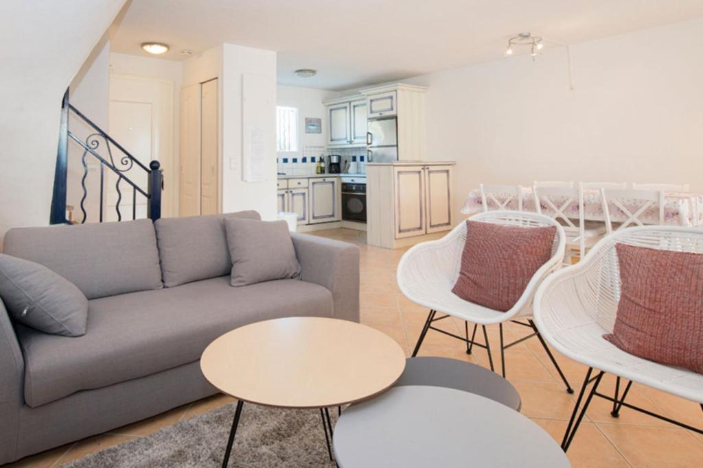 uma sala de estar com um sofá, uma mesa e cadeiras em Bonheur - Vakantiewoning Côte d'Azur em Roquebrune-sur-Argens