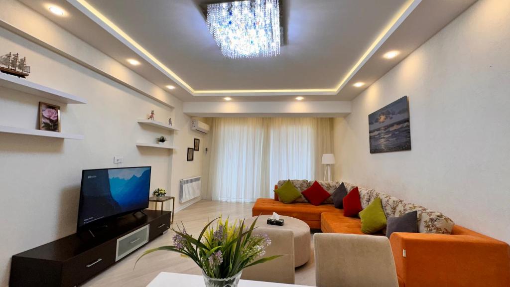 uma sala de estar com um sofá e uma televisão em Azure Residence em Baku