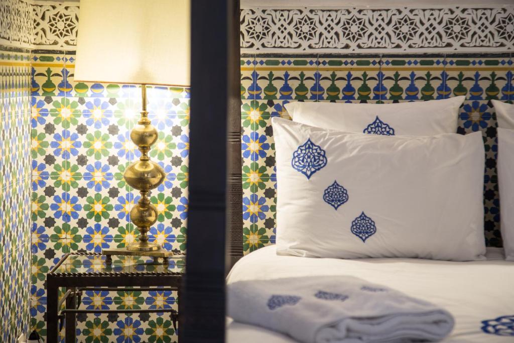 a bedroom with a bed with blue and white at Ryad El Borj in Marrakech