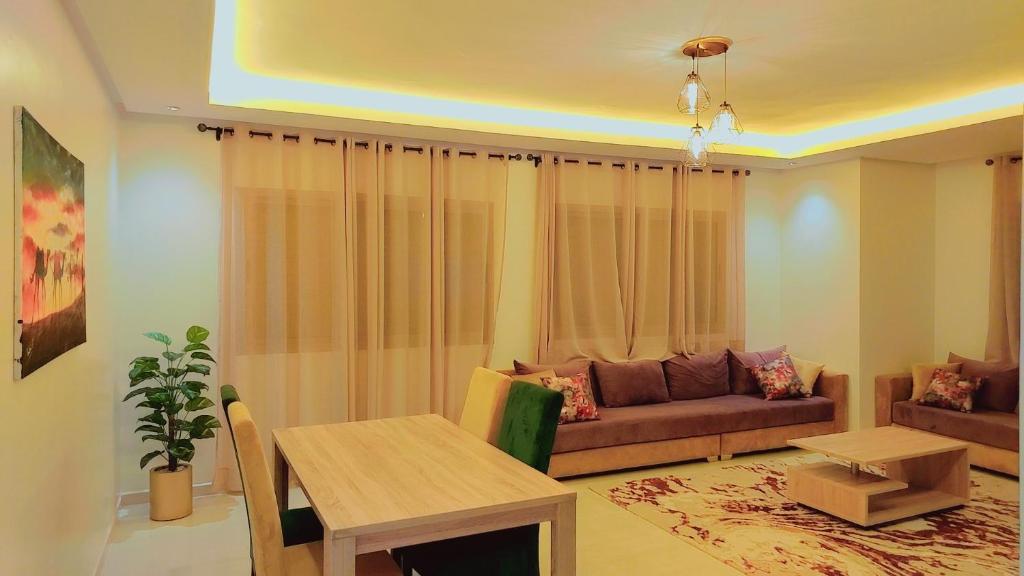 Appartement Perla - Costa Bouznika في بوزنيقة: غرفة معيشة مع أريكة وطاولة