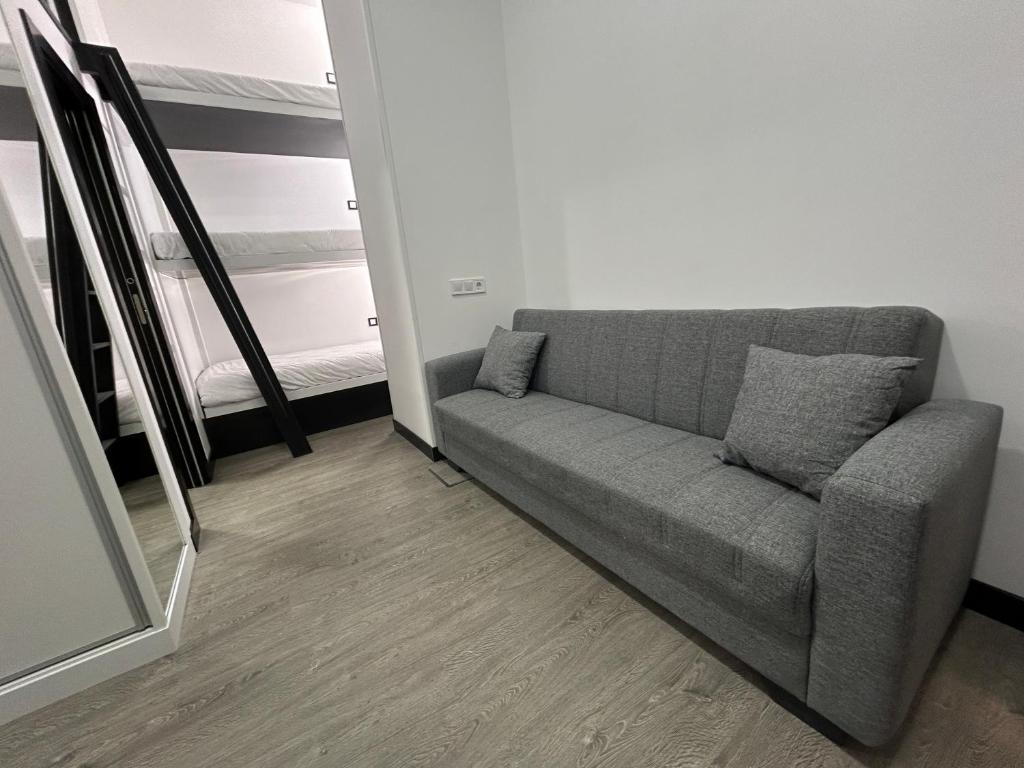 a gray couch in a room with a window at Cotrades 2 San Blas-canillejas in Madrid