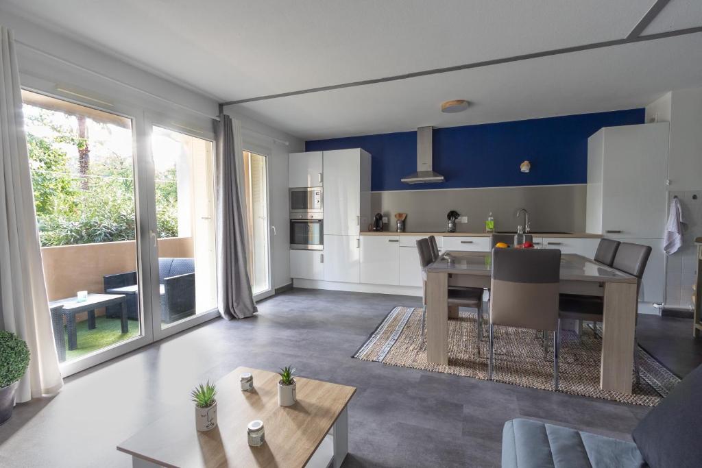 une cuisine et un salon avec une table et une salle à manger dans l'établissement Le Petra - Appt climatisé proche de la plage, à Ajaccio