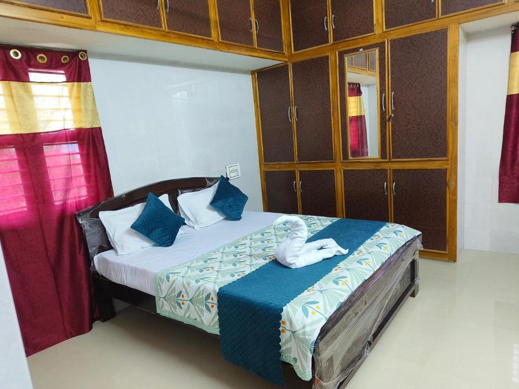 um quarto com uma cama com lençóis azuis e almofadas azuis em V1 Stay Home em Tirupati