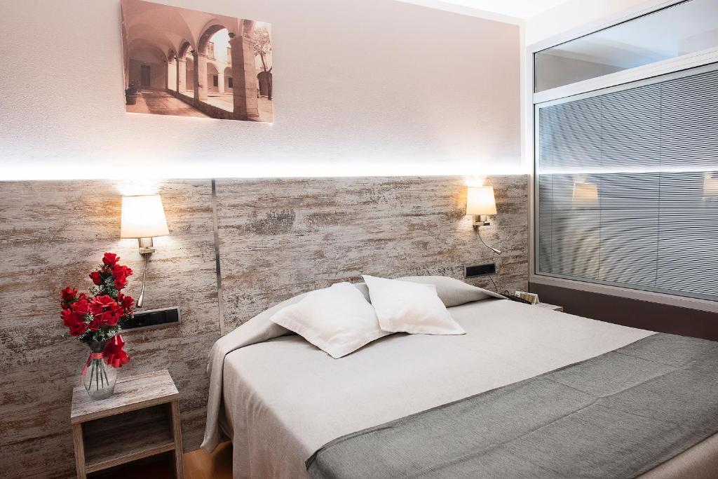 Postel nebo postele na pokoji v ubytování Hotel Palau de Girona