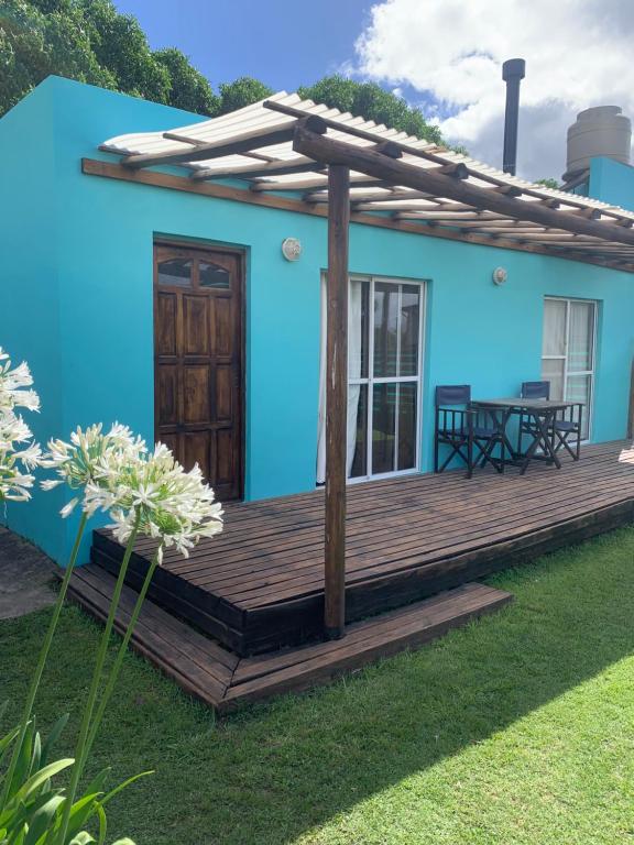 玛尔德科博Casa a 50 mts de la playa的蓝色的房屋,设有木甲板